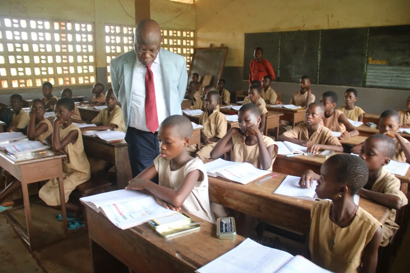 Le ministre Salimane Karimou appréciant les performances des élèves dans  les cahiers d’activités individuellement reçus