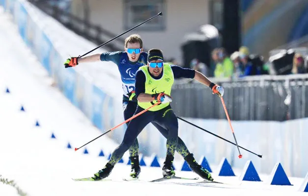 Maksym Murashkovskyi (derrière son guide), un médaillé  d’argent guidé par la technologie